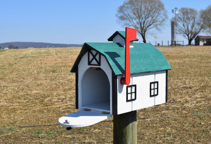 white and green barn mailbox with red flag and open door